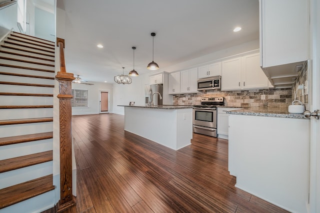 kitchen with white cabinetry, ceiling fan, dark hardwood / wood-style floors, pendant lighting, and appliances with stainless steel finishes