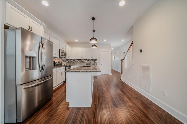 kitchen with a center island with sink, white cabinets, sink, and appliances with stainless steel finishes