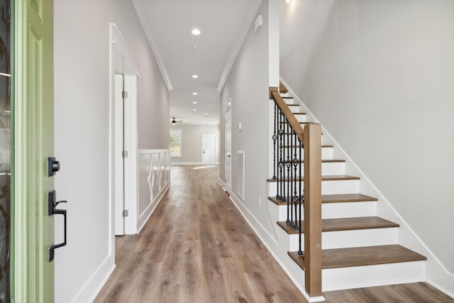 corridor featuring light wood-type flooring and ornamental molding