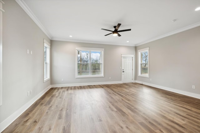 unfurnished room with crown molding, plenty of natural light, and light hardwood / wood-style floors