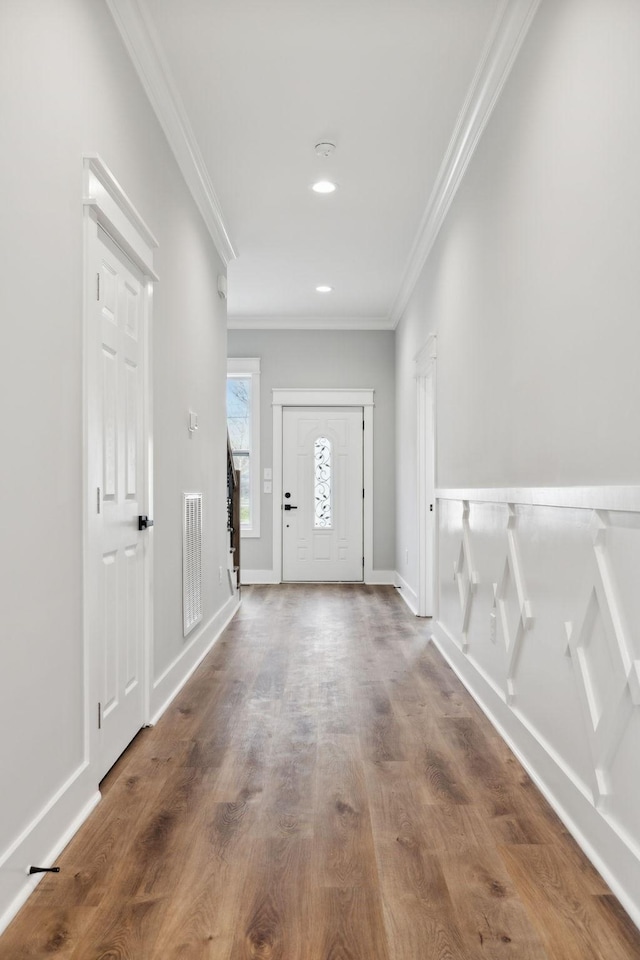 entryway with hardwood / wood-style floors and crown molding