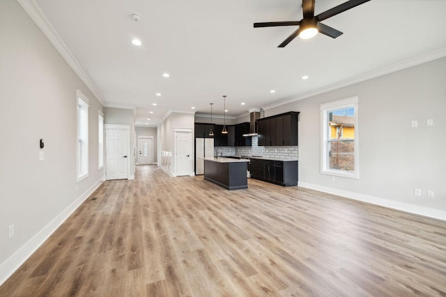 unfurnished living room featuring hardwood / wood-style flooring, ceiling fan, and ornamental molding