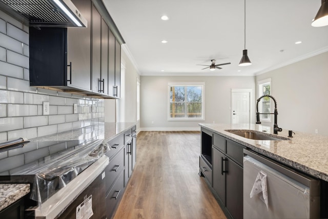 kitchen featuring light stone countertops, sink, light hardwood / wood-style flooring, decorative light fixtures, and appliances with stainless steel finishes