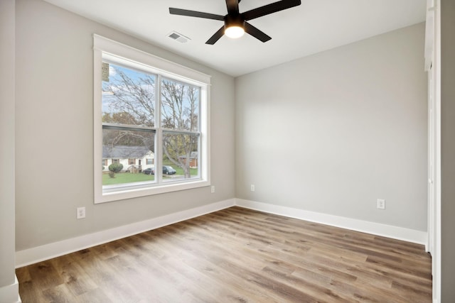 spare room featuring a wealth of natural light, ceiling fan, and hardwood / wood-style flooring