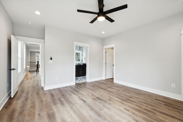 unfurnished bedroom featuring light hardwood / wood-style floors, ensuite bath, and ceiling fan