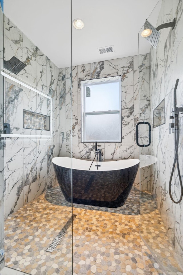 bathroom with tile walls and shower with separate bathtub