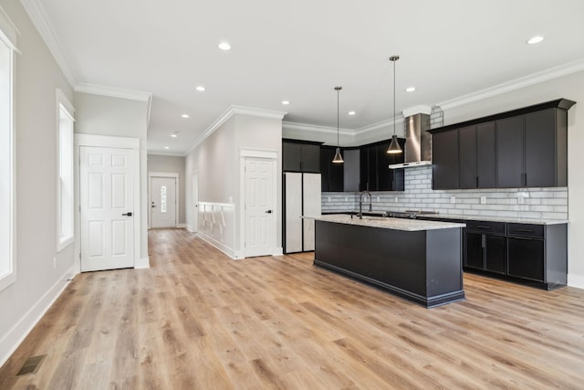 kitchen with backsplash, wall chimney exhaust hood, light hardwood / wood-style floors, and ornamental molding