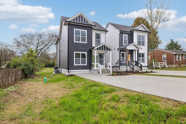 view of front of property with central AC unit and a front yard