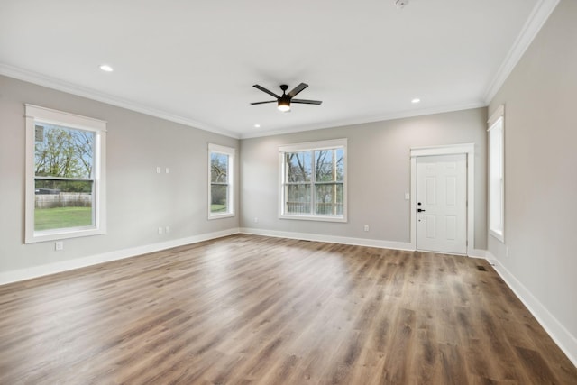 unfurnished room featuring hardwood / wood-style flooring, crown molding, and a wealth of natural light