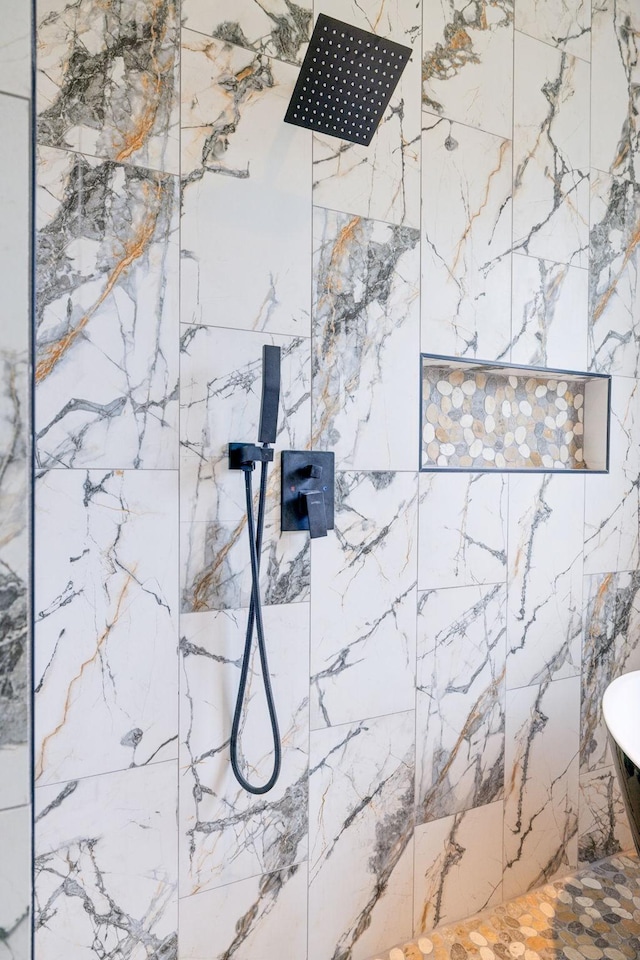 interior details featuring tiled shower