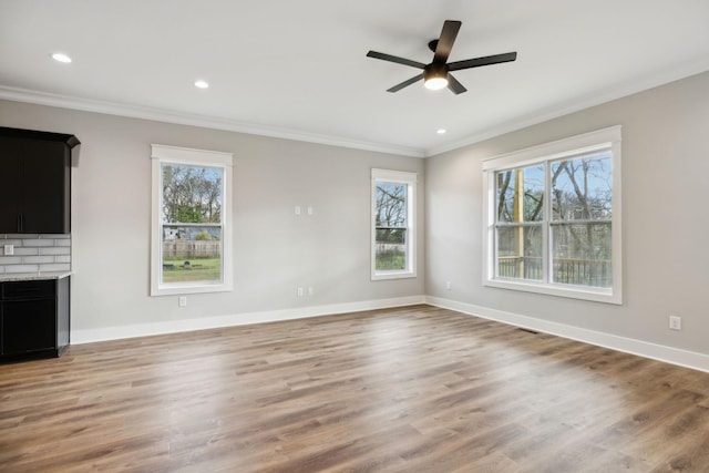 unfurnished living room featuring wood-type flooring, ceiling fan, and crown molding