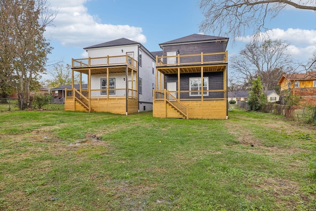 back of property with a lawn, a wooden deck, and a balcony