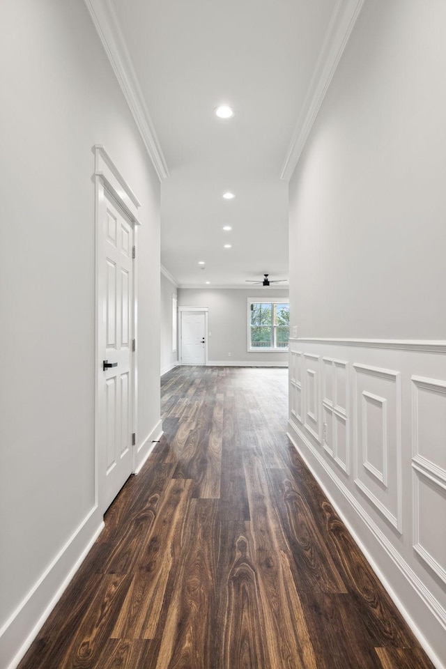 hallway with dark hardwood / wood-style floors and crown molding