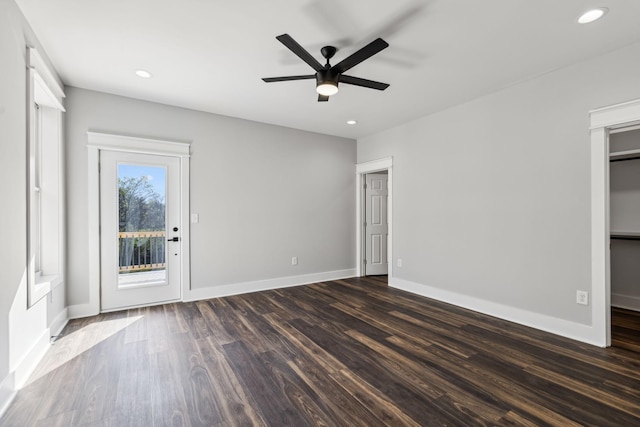 empty room with ceiling fan and dark wood-type flooring