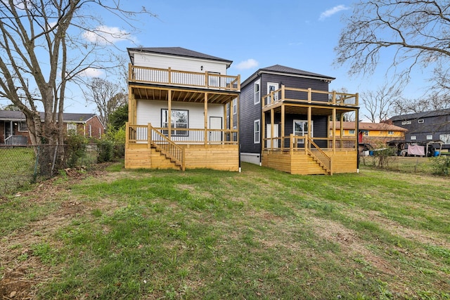 rear view of house featuring a yard, a balcony, and a deck