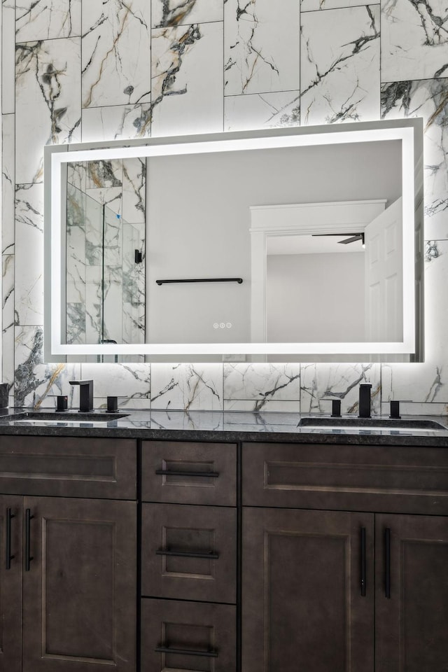 bathroom featuring vanity, an enclosed shower, and backsplash