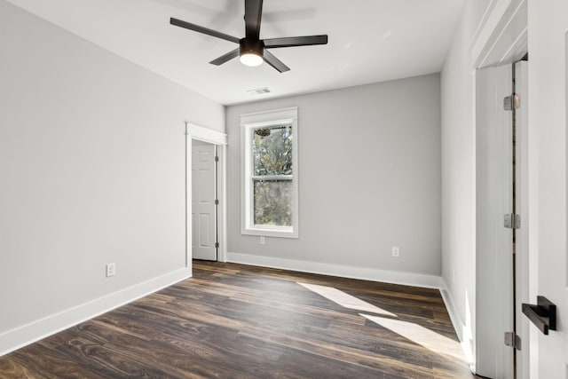 unfurnished room with ceiling fan and dark wood-type flooring