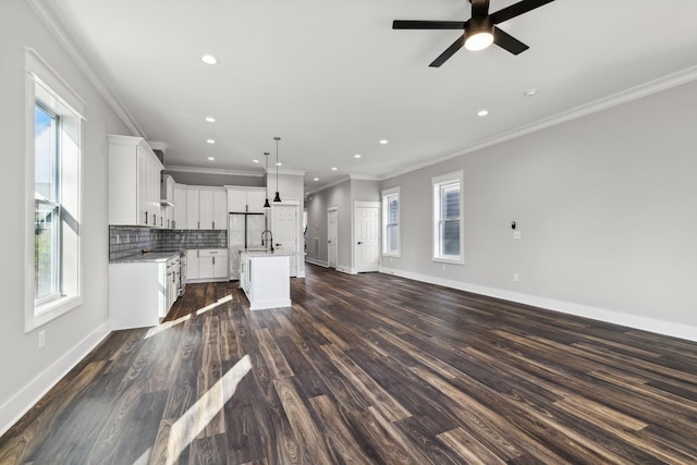 unfurnished living room with dark hardwood / wood-style floors, ceiling fan, ornamental molding, and sink