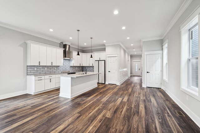 kitchen with a kitchen island with sink, white refrigerator, wall chimney range hood, dark hardwood / wood-style floors, and white cabinetry