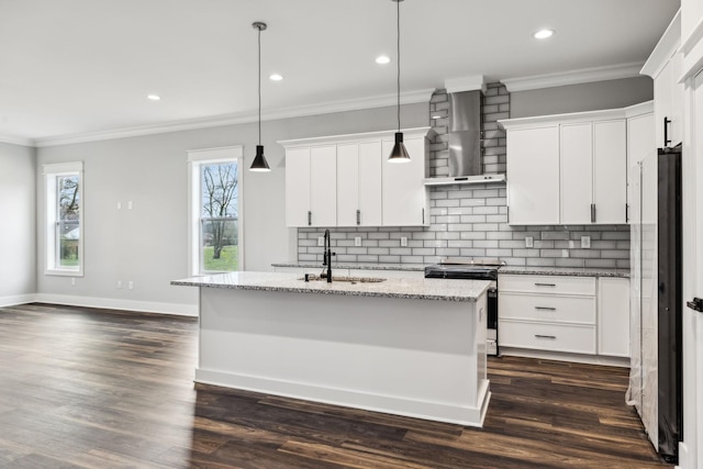 kitchen with wall chimney range hood, white cabinets, hanging light fixtures, and stainless steel electric range