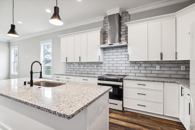 kitchen featuring stove, wall chimney exhaust hood, sink, white cabinets, and an island with sink