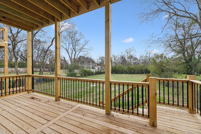 wooden deck featuring a lawn