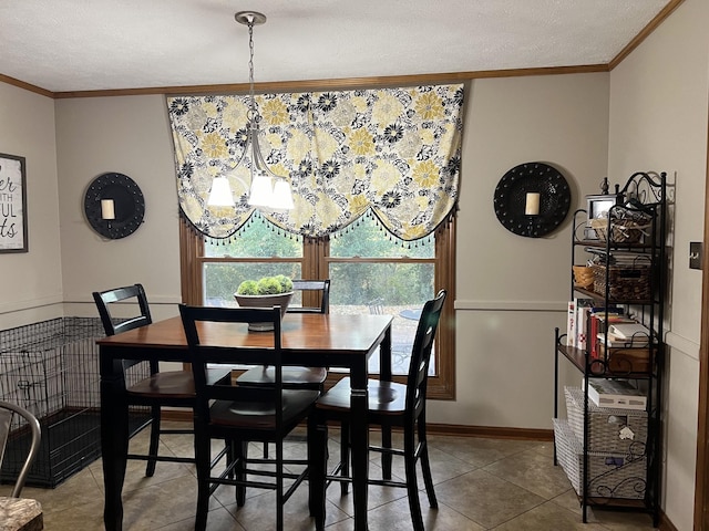 tiled dining room with a chandelier, a textured ceiling, and ornamental molding