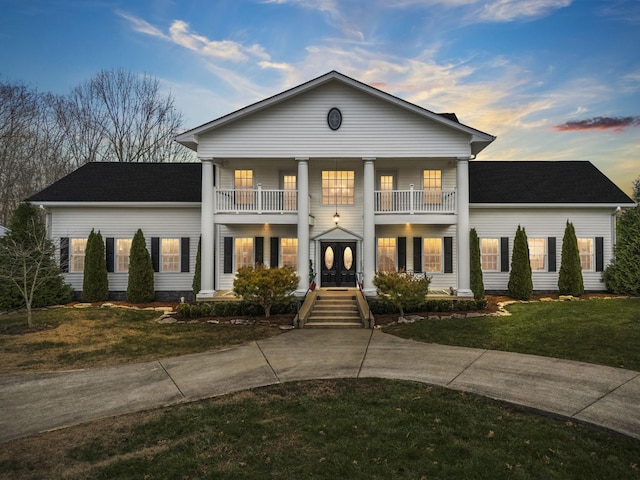 greek revival inspired property featuring a yard and a balcony