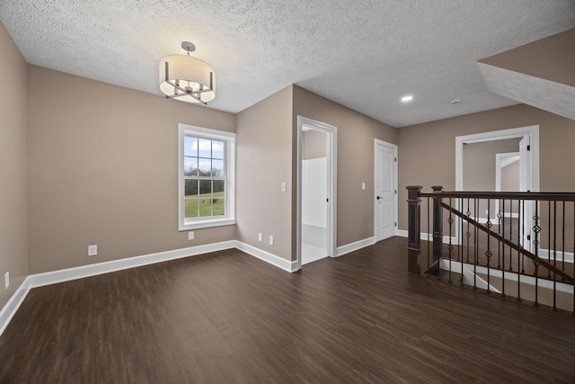 unfurnished room featuring dark hardwood / wood-style flooring and a textured ceiling