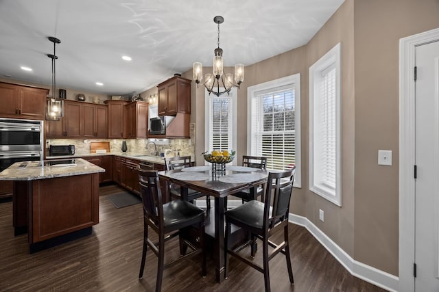 dining area featuring dark hardwood / wood-style flooring, an inviting chandelier, and sink