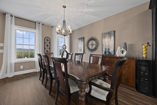 dining room featuring an inviting chandelier and dark wood-type flooring