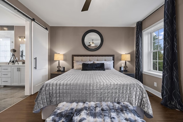 bedroom with multiple windows, a barn door, ceiling fan, and dark wood-type flooring