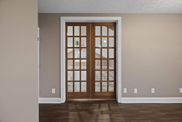 interior space with wood-type flooring, a textured ceiling, and french doors