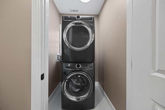 laundry area featuring stacked washer / dryer