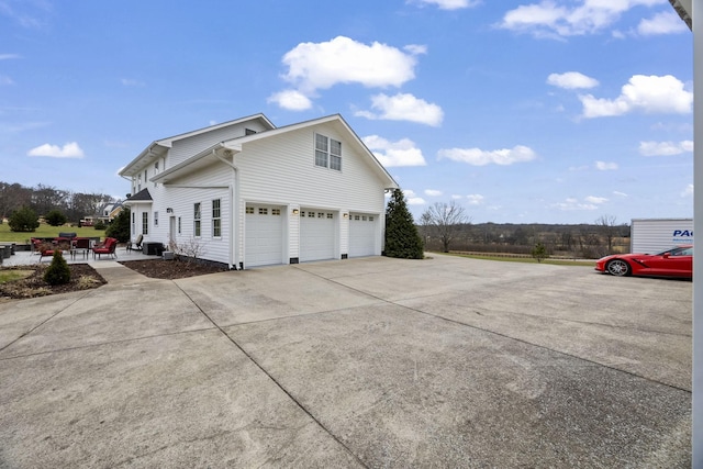 view of property exterior featuring a patio area and a garage