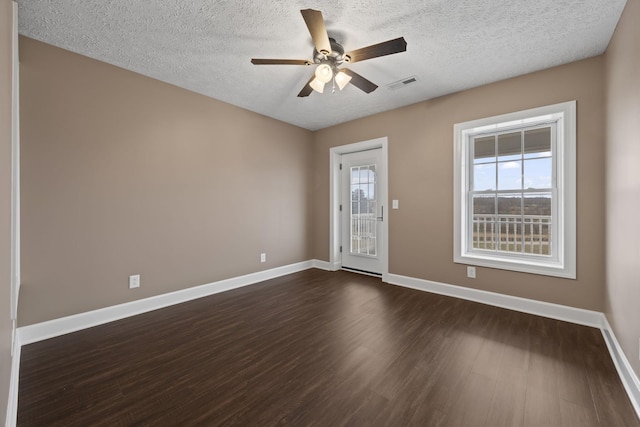 empty room with a textured ceiling, dark hardwood / wood-style flooring, and ceiling fan