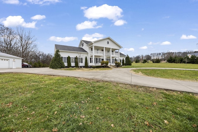 view of front of house featuring a porch, a balcony, and a front yard