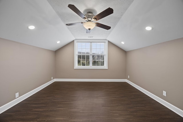 additional living space with a textured ceiling, dark wood-type flooring, ceiling fan, and lofted ceiling