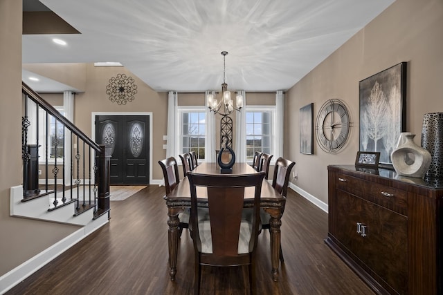 dining room featuring dark hardwood / wood-style floors, an inviting chandelier, and lofted ceiling