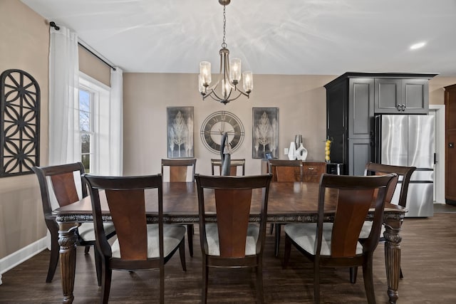 dining space featuring dark hardwood / wood-style flooring and an inviting chandelier