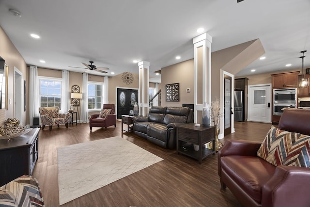 living room with ornate columns, ceiling fan, and dark wood-type flooring