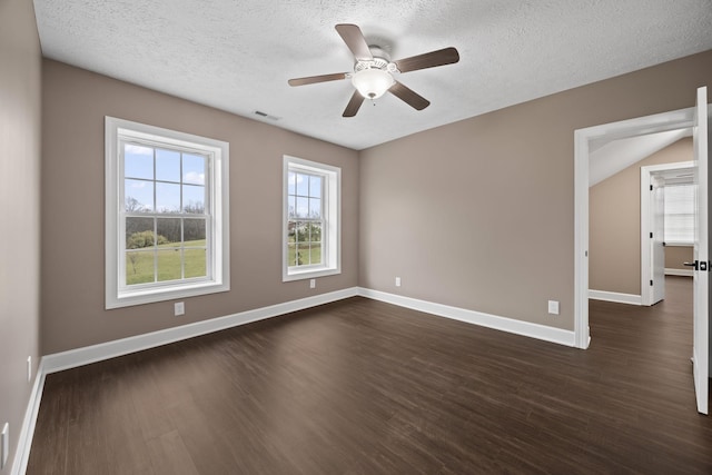 spare room featuring a textured ceiling, ceiling fan, dark hardwood / wood-style flooring, and plenty of natural light