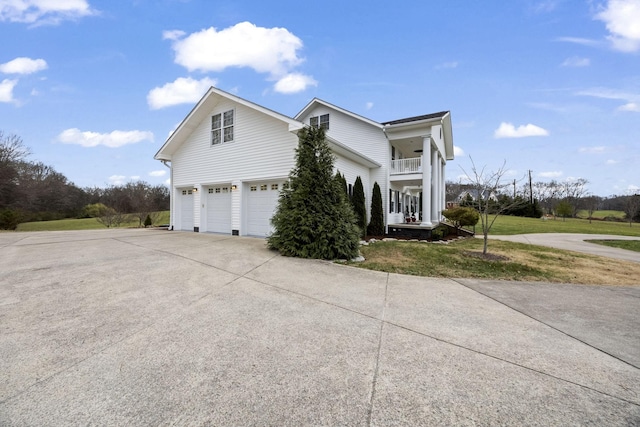 view of front of home featuring a garage, a balcony, and a front lawn