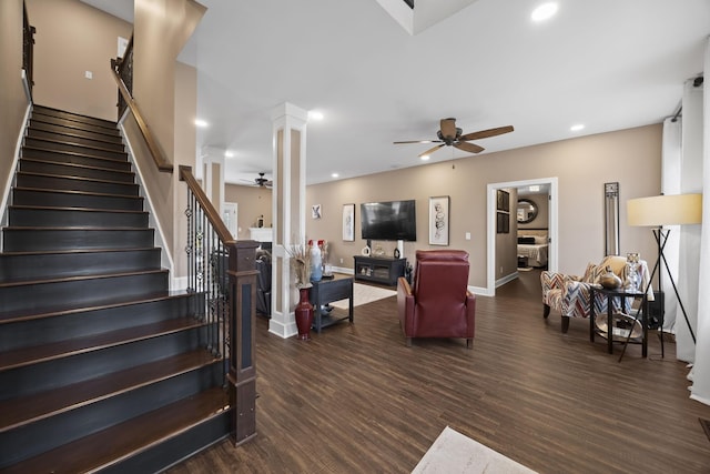 living room featuring ceiling fan, ornate columns, and dark wood-type flooring