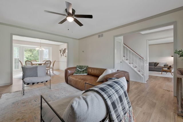 living room featuring ceiling fan with notable chandelier, crown molding, and light hardwood / wood-style flooring