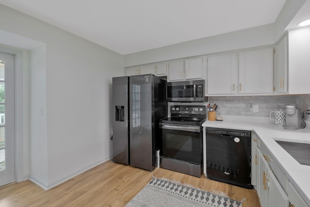 kitchen featuring backsplash, sink, light hardwood / wood-style floors, white cabinetry, and stainless steel appliances