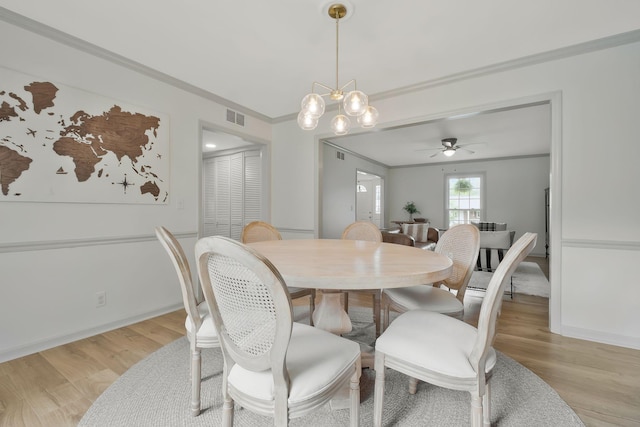 dining space featuring ceiling fan with notable chandelier, light hardwood / wood-style floors, and ornamental molding