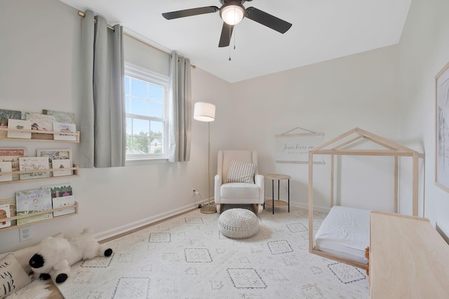 living area featuring light carpet and ceiling fan