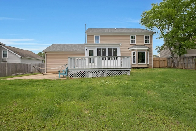 rear view of house with a wooden deck and a yard