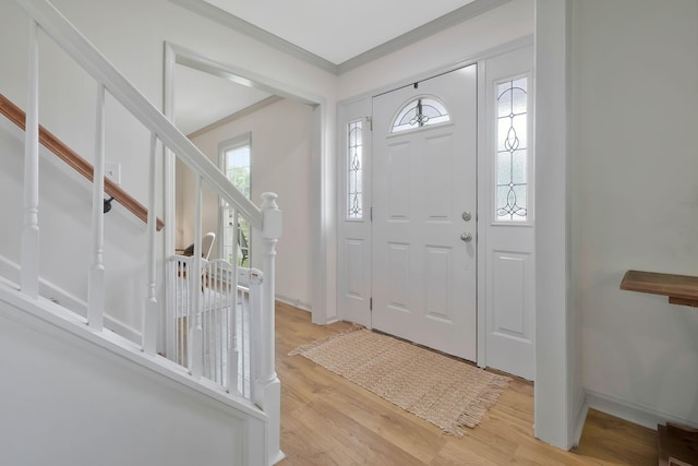 foyer with crown molding and light hardwood / wood-style flooring